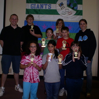 DePauw Debate Outreach Assistants Avery Archer and Jessica Hawkins stand with the Debate Champions at Greencastle's Tzouanakis Intermediate School.  The DePauw Debate Society successfully ran an After School Enrichment Program at the school in 2009.