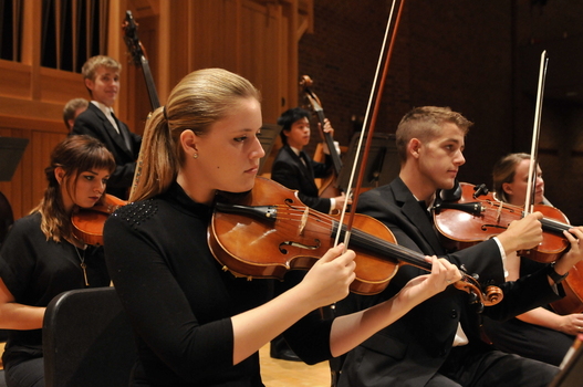 Students playing violin in the DePauw University Orchestra
