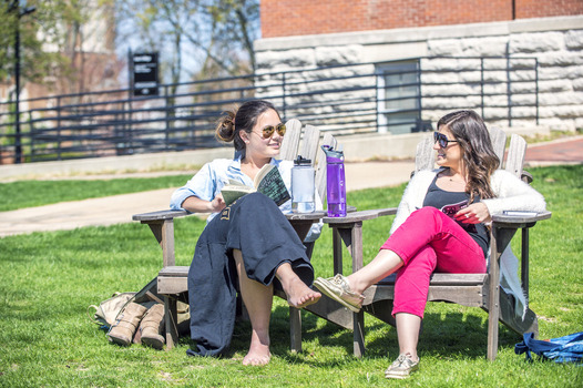 Students sitting in chairs on the East College lawn