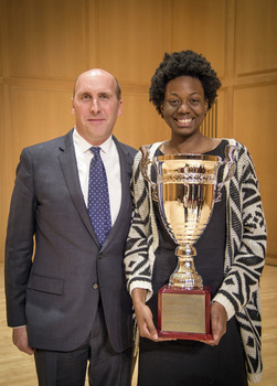 Student holding an award next to Brian Casey