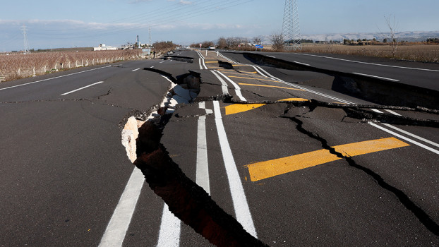 Photo of broken highway with massive cracks from earthquake fault line