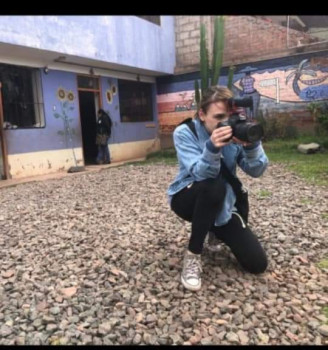 person kneeling outside holding camera