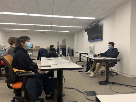 Several students attending an After Effects workshop and looking at the presentation.