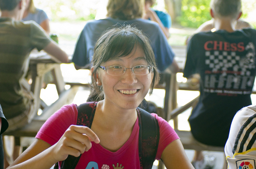 An international student smiling during an outside event on campus
