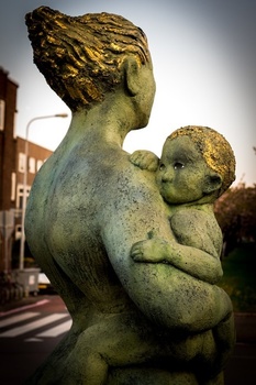 Statue of woman holding a child. 