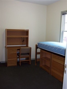 Single-occupancy bedroom within Rector Village with a low-lofted bed