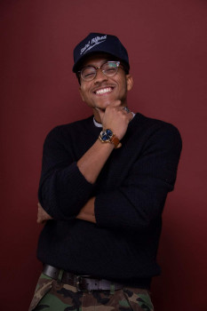 male standing with baseball style hat on