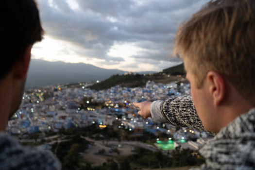 students look out over a Moroccan city at sunset