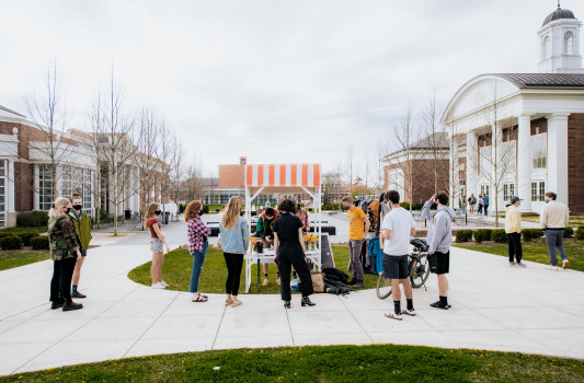 people gather outside stewart plaza for a farm stand