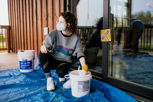 Director uses natural dye to color a t-shirt outside of the Ullem Center