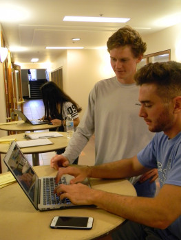 Intern walking a student through adding wireless network access to their laptop.