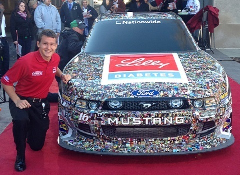Eric Bruynseels ('15) interned at Lilly, pictured with race car driver Ryan Reed's car during a promotional event.