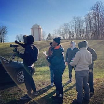 group of people and a camera pointing they are outside