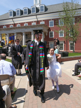 Graduate walking with their sibling in front of Roy O. West