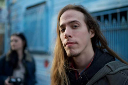 Person with long hair headshot with blue background