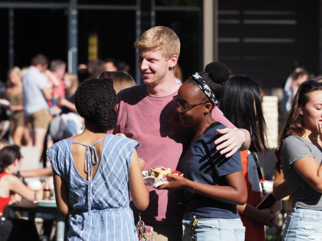 Students hugging while enjoying a meal together