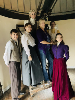 people in costume standing on the stairs of the large telescope