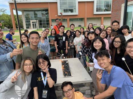 a group of students gathered around a table smiling