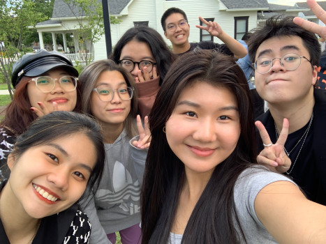 Seven students grouped together flashing peace signs