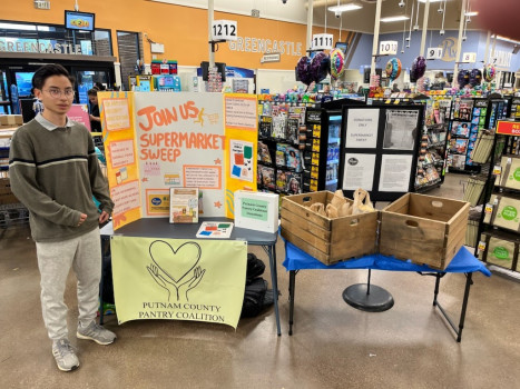 A student is tabling at Kroger for the Supermarket Sweep event. 