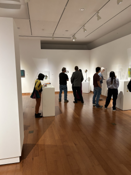 Images of people walking through the Vietnam in the Midwest exhibit on the 2nd floor of the Richard E. Peeler Art Center