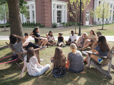 Students attending an outside class under the trees