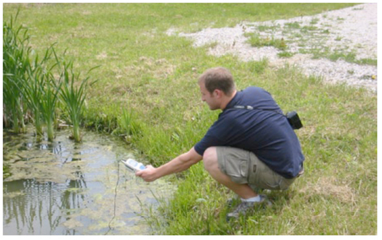 Student measuring pH to help determine surface water quality.