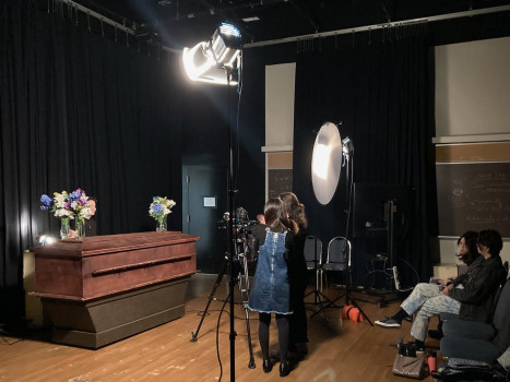 coffin with lights and video recording devices and four people