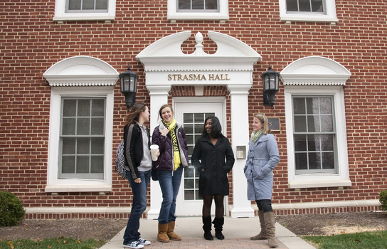 Students grouped in front of Strasma Hall in Rector Village