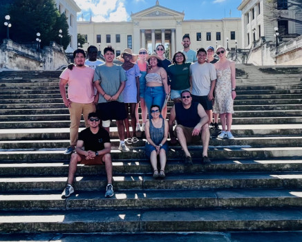 Students posing together on steps in Cuba