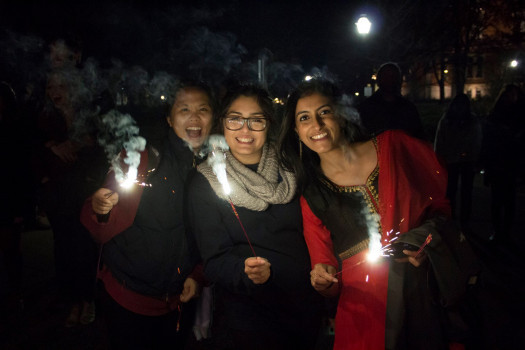 Students celebrating at night with sparklers