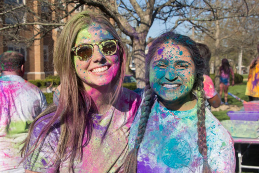 Students smiling covered in paint