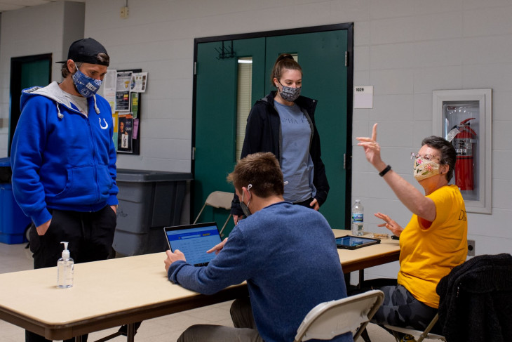 Volunteer directs student to get his shot