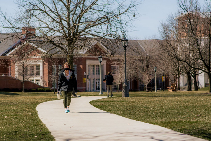 Student walking along a path on campus 