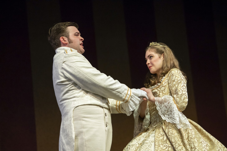 A man and woman holding hands in 18th century costumes