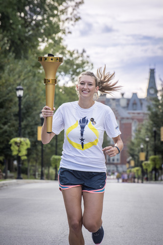 Student carrying a torch while running down Anderson Street