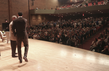 Andrew Luck walking on stage shaking hands with Bill Lynch