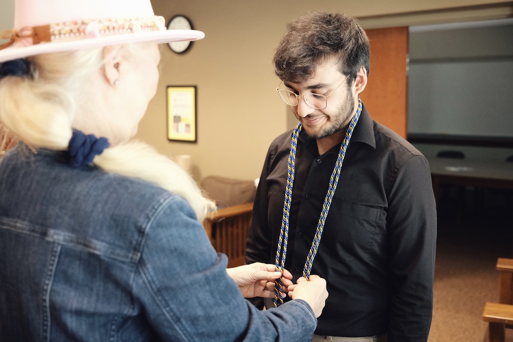 Gloria Townsend gives Taha Babar his honor cords