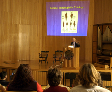 robert Waterson and the crowd during an Ubben Lecture with slide presentation in the background