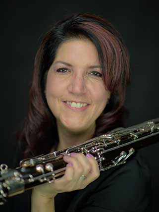 Smiling woman holding bassoon