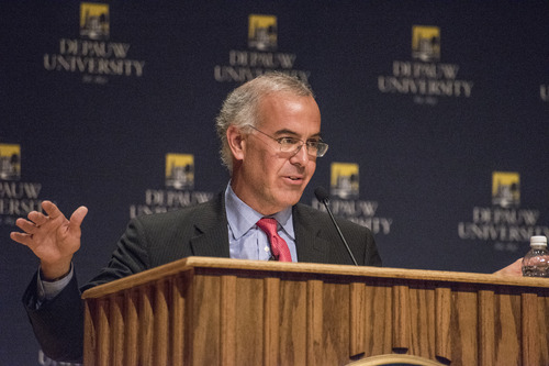David Brooks at lectern with outstretched arms
