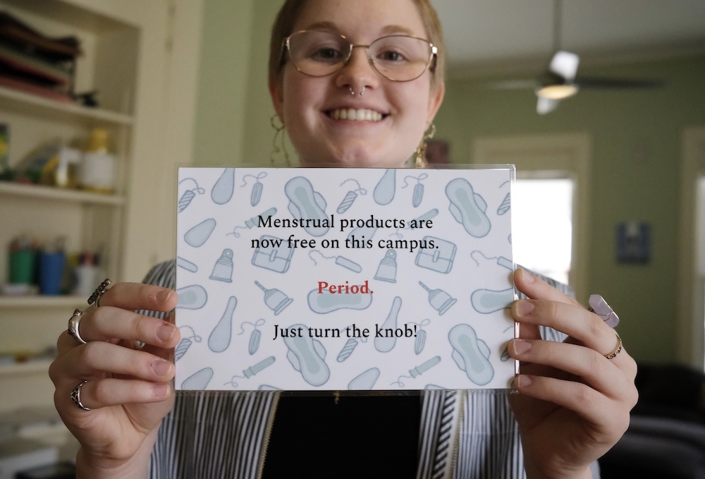 Paige Burgess '25 holds a sign telling students how to use the updated vending machines