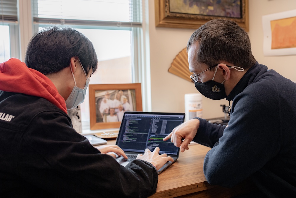 a student and faculty member debug code together