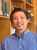 Jin Kim headshot with books in the background