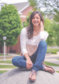 Tazree Kadam sitting on the boulder in front of East College