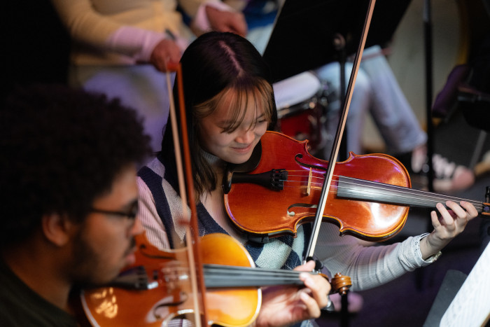 Two students rehearsing violin reading sheet music