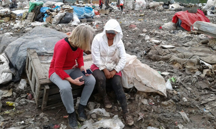 Betsy Hake engages with a woman working in a dump