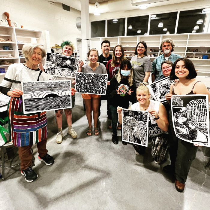 group of artists holding woodblock prints