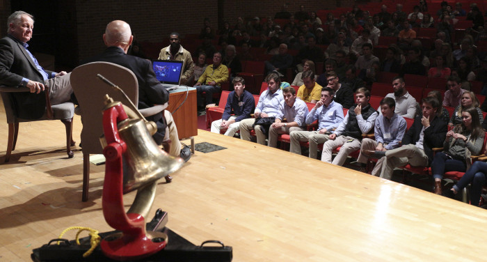 Bill Rasmussen and Ken Owen on stage facing the crowd with the Monon Bell