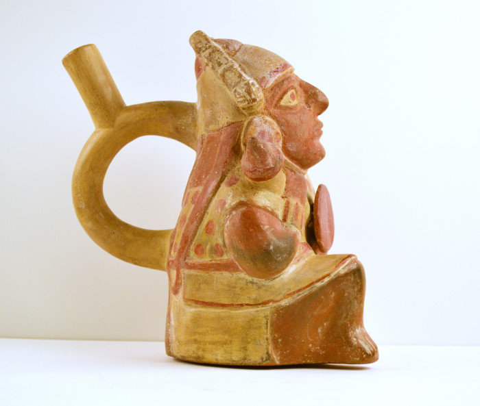 Figural vase with a circular shaped handle with a medium length spout 